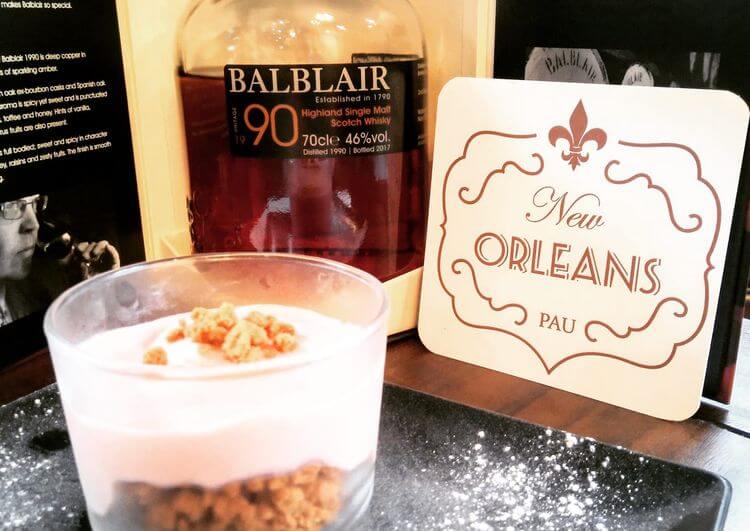 Le logo du New Orleans, restaurant à Pau, avec une verrine en premier plan et du Whisky, la spécialité du restaurant.