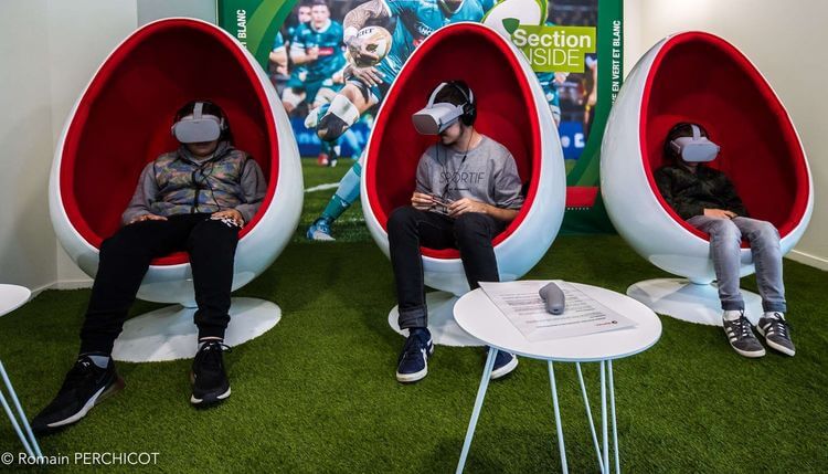 Trois jeunes testent les lunettes immersives 3D pour se mettre à la place d'un joueur de rugby.