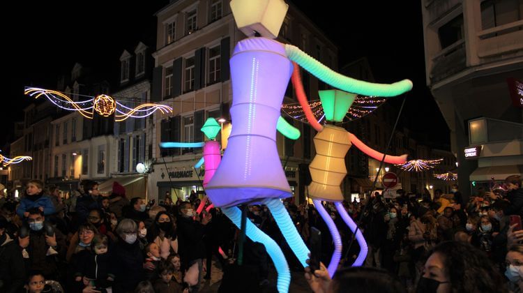 La compagnie Les Big Dancers portent des marionnettes géantes illuminées à Pau lors de la déambulation de la Fête des Lumières, en décembre 2021