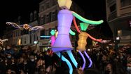 La compagnie Les Big Dancers portent des marionnettes géantes illuminées à Pau lors de la déambulation de la Fête des Lumières, en décembre 2021