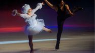 Deux danseurs de la troupe Féerie sur Glace en pleine représentation artistique.