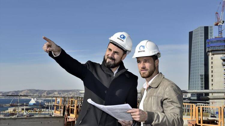 Deux employés de Socotec observent un chantier de l'entreprise.