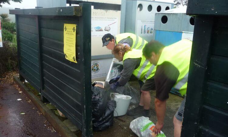 Trois membres de l'association Adeli ramassent des déchets.
