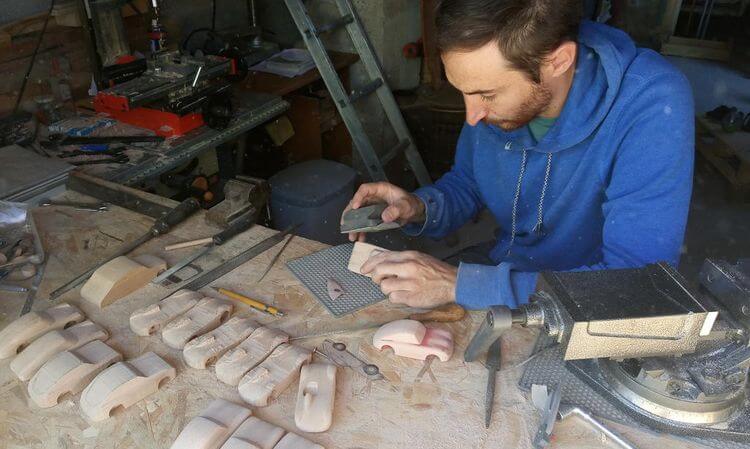 Jérémy Martinez travaille sur une série de voitures en bois dans son atelier dans le Béarn.