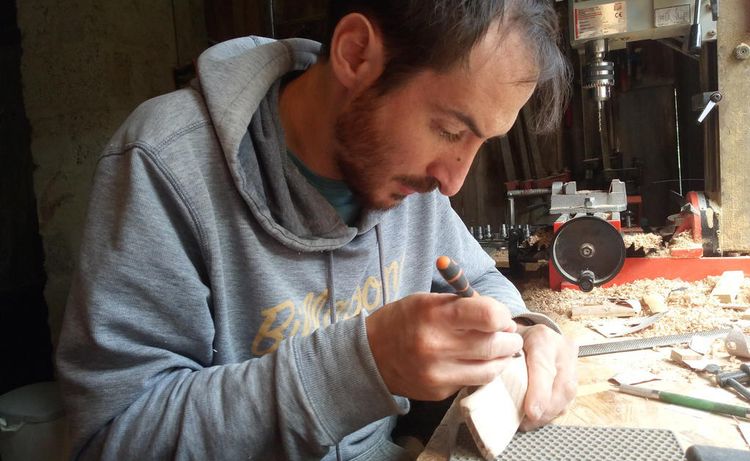 Jérémy Martinez travaille sur une voiture en bois dans son atelier dans le Béarn.