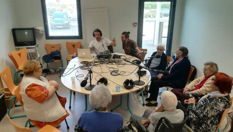 Deux membres d'Hapchot Radio animent une émission en compagnie de personnes âgées.