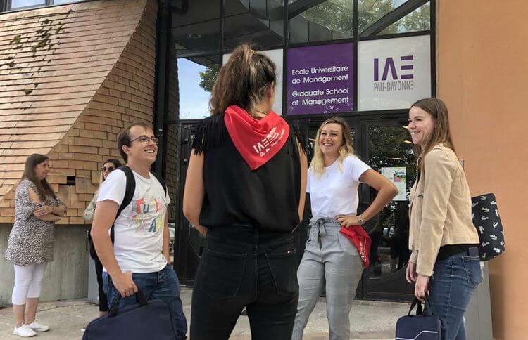 Des étudiants de l'IAE Pau-Bayonne discutent devant le campus de Pau.