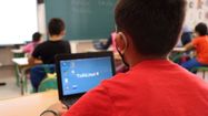 Un enfants est en classe avec un ordinateur équipé du programme d'exploitation Txikilinux.