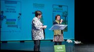 Deux femmes sur scènes prennent la parole pendant l'Assemblée Générale de l'Association Départementale des Gîtes de France des Pyrénées-Atlantiques.