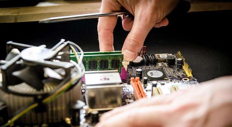 Une personnes en train de réparer des composants électroniques.