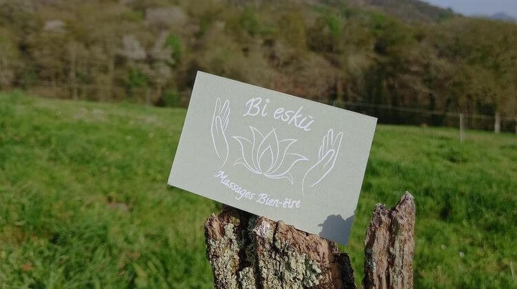Une photo de la carte de visite de Sandrine Biguet dans un paysage du Pays Basque.