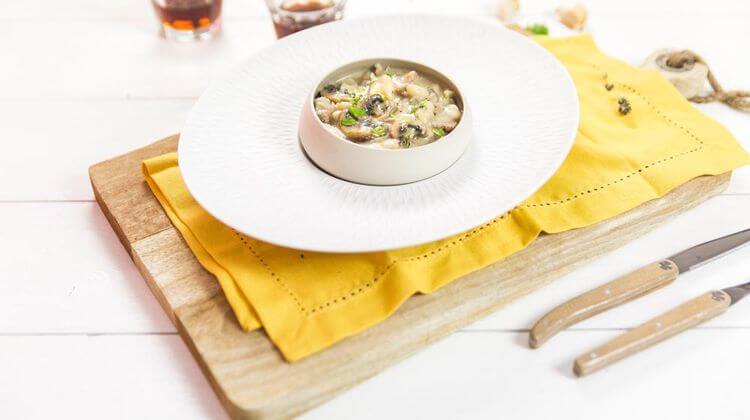 Assiette ronde posé sur une serviette jaune, garnie de haricots tarbais au marsala