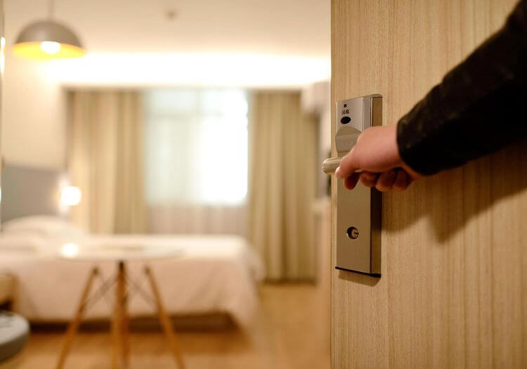 La main d'un personne sur une poignée entrant dans une chambre d'hotel