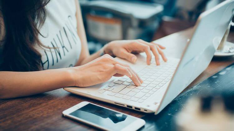 Une jeune femme travaille sur son ordinateur portable.