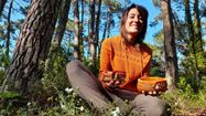 Audrey Mousseau pose avec deux de ses paniers, dans la forêt des Landes.