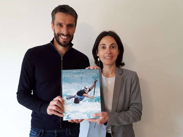 Tony Estanguet et Elsa Krim tenant la bande dessinée Tony, l'enfant des rivières, illustrée par Frédéric Campoy.