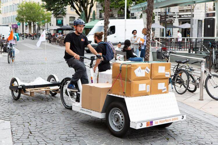 Livreur sur son vélo livrant les colis dans les rues de Pau