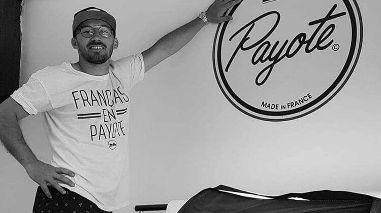 Olivier Gelly, le fondateur de la marque d'espadrille Payote, posant à côté du logo de sa marque.