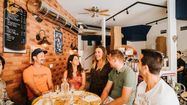 Plusieurs personnes dont Marine Nicolau sont autour d'une table dans un restaurant.