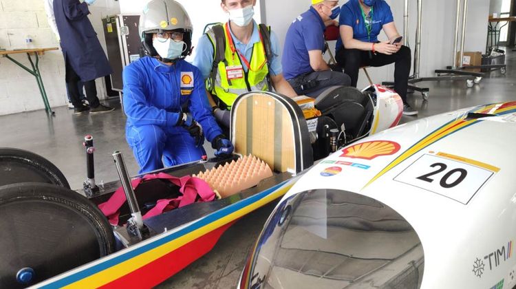 2 étudiants devant leur prototype de véhicule dans l'atelier de la compétition internationale Shell Eco-marathon.