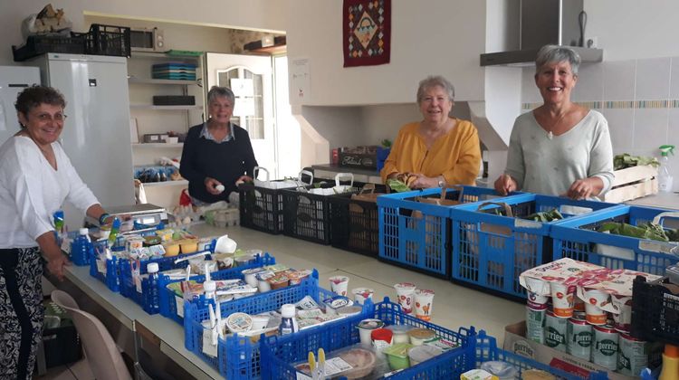 Des bénévoles de l'association Le Panier en train de préparer des paniers alimentaires pour l'épicerie solidaire de Gan.
