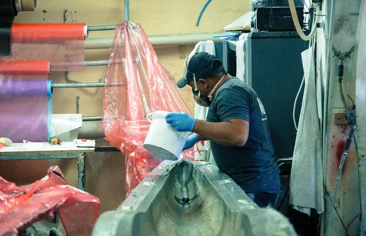 Un homme travaille sur la fabrication d'une pirogue dans les ateliers de WOO.