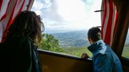 Deux personnes profitent de la vue à bord du train de la Rhune au Pays basque.