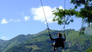 Une personne fait de la balançoire géante en face des montages des Pyrénées au Parc Oba'O d'Accous.
