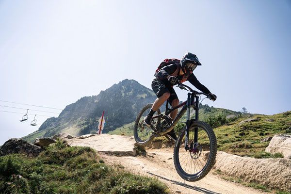 Un cycliste prend une bosse en VTT dans les Pyrénées.