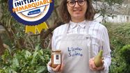 Virginie posant en toque avec un pot de compote et une poire dans la main