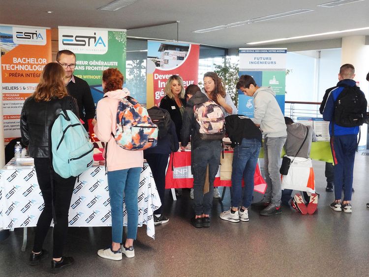 Des jeunes s'informent auprès de stands installés dans le hall de l'aéroport de Pau pour le salon AéroAdour 2018.