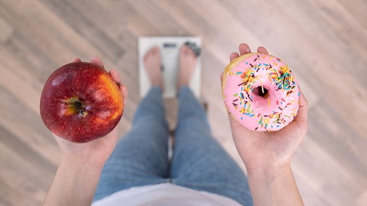 Photo d'une personne tenant un donuts et une pomme