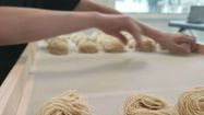 Un artisan pastier travaillant la forme de ses pâtes.