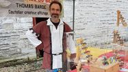 Thomas Bardes, artisan coutellier à Pau, tenant un stand d'exposition de ses produits