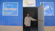 Un homme sort d'une station de production d'eau potable de 1001Fontaines sponsorisée par Fleurance Nature.
