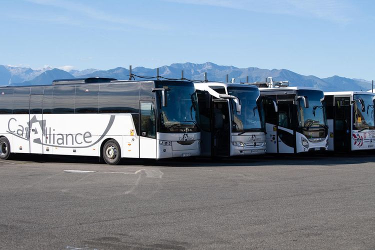 Des autocars Caralliance exposés sur le parking de l'entreprise.