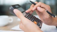 Photo d'une personne faisant ses comptes avec une calculatrice