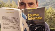 Alain Mila caché derrière son livre Course Infernale.