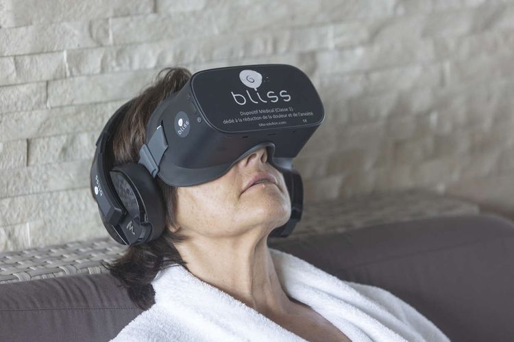 Une curiste teste le masque de réalité virtuelle Bliss, pour réduire la douleur et l’anxiété.
