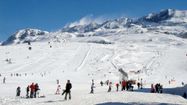 Une photo d'une montagne enneigée avec des skieurs.