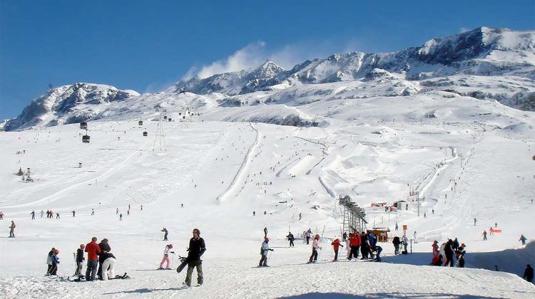 Une photo d'une montagne enneigée avec des skieurs.