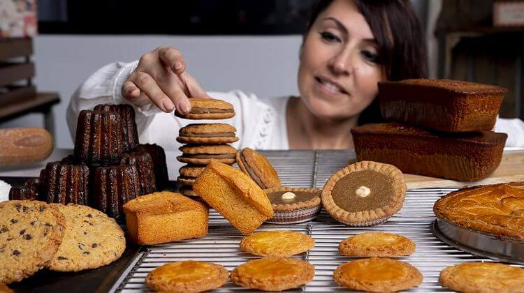 Émilie Farrera faisant une pyramide de gateau sur une grille avec d'autres patisserie
