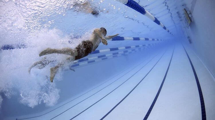 un homme nage dans le couloir d'une piscine municipale