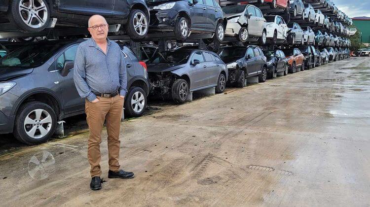 Photo de Philippe Alberdi devant des voitures stockées dans sa casse