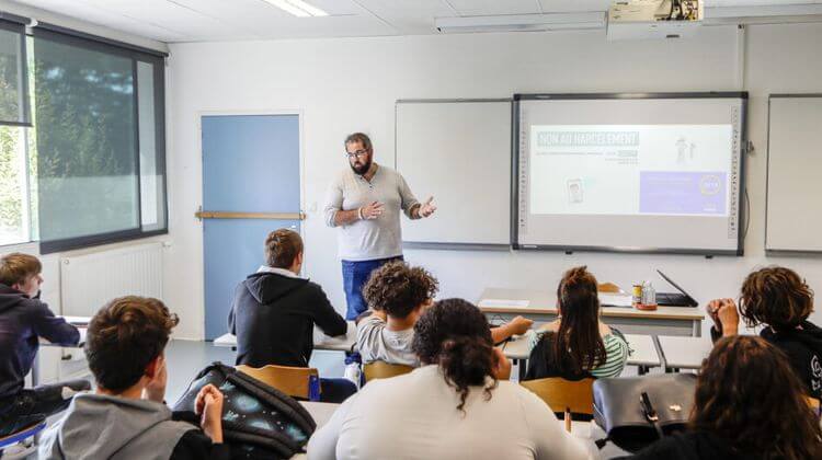 Julien, l'ambassadeur du réseau des Promeneurs du Net, parle à des élèves dans une salle de classe.