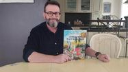 Pascal Cazaubon pose avec sa bande dessinée Opération Rastaquouère.