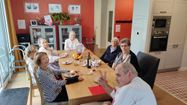 Des résidents d'une résidence pour seniors autour d'une table lors d'un repas.