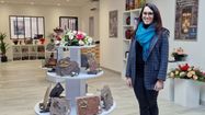Camille Berot dans son magasin, avec des fleurs, des plaques mortuaires
