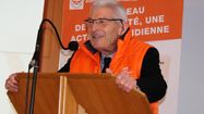 Pierre Buffo, président de la Banque Alimentaire du Gers, face à un micro et un pupitre