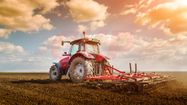Un tracteur laboure un champs.
